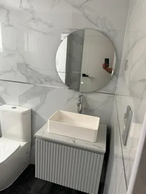 a white bathroom with a sink and a mirror at Torre DOÑA EVA in Santo Domingo