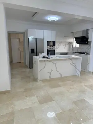 a large kitchen with white cabinets and a tile floor at Torre DOÑA EVA in Santo Domingo