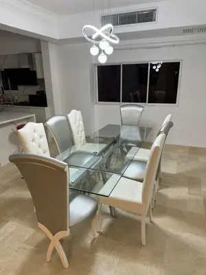 a dining room with a glass table and white chairs at Torre DOÑA EVA in Santo Domingo