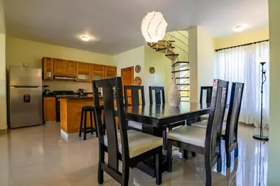 a kitchen and dining room with a black table and chairs at Pro Cab Paradise Condos Cabarete in Cabarete