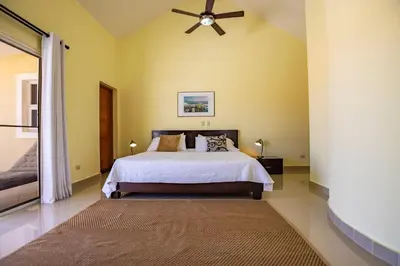 a bedroom with a bed and a ceiling fan at Pro Cab Paradise Condos Cabarete in Cabarete