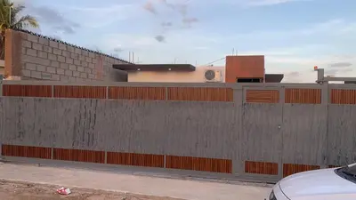 a building with a concrete wall next to a parking lot at Residencial Fe y Esperanza in Pedernales