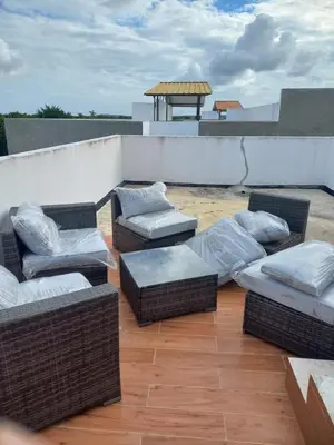a patio with wicker chairs and couches on a roof at Apartamento en Vista Cana in Batey San Germán