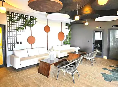 a living room with a white couch and chairs at Comfortable apartmento en el centro de la ciudad con piscina y gym in Santo Domingo