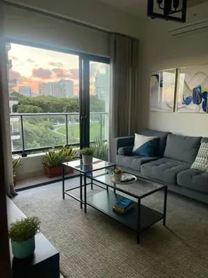 a living room with a couch and a table at Comfortable apartmento en el centro de la ciudad con piscina y gym in Santo Domingo