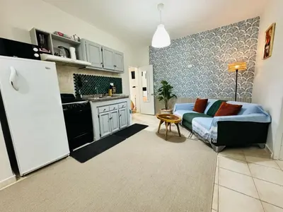 a living room with a blue couch and a kitchen at Central, a 5 Minutos de Playa, AC, Piscina, Cómodo, Bares, Rest in Sosúa