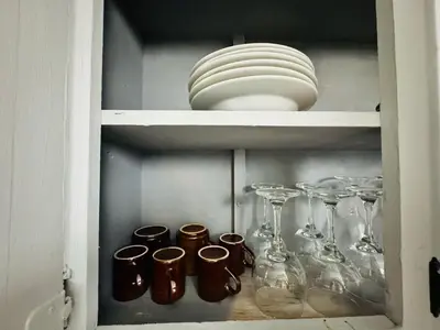a cupboard with wine glasses and plates on it at Central, a 5 Minutos de Playa, AC, Piscina, Cómodo, Bares, Rest in Sosúa