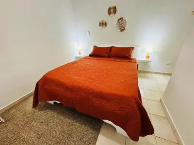 a bedroom with a large orange bed with two lamps at Central, a 5 Minutos de Playa, AC, Piscina, Cómodo, Bares, Rest in Sosúa