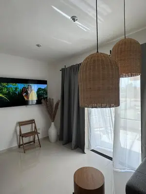 a living room with two pendant lights and a tv at Terraza Caribeña in Bayahibe