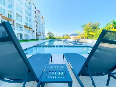 a couple of chairs sitting next to a swimming pool at Fortunity1 Escape, Puerto plata Playa Dorada in San Felipe de Puerto Plata