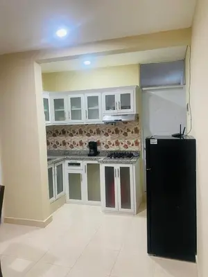 a kitchen with white cabinets and a black refrigerator at Apartamento Familiar 7 in Colorado