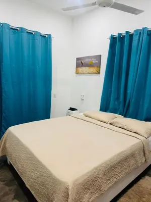 a bedroom with blue curtains and a bed at El patio de Lucia, center 4 people Las Terrenas in Las Terrenas