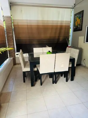 a dining room with a black table and white chairs at El patio de Lucia, center 4 people Las Terrenas in Las Terrenas