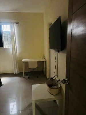 a room with a desk and a television on a wall at El patio de Lucia, center 4 people Las Terrenas in Las Terrenas