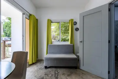 a room with a chair and a table and a window at El Patio de Lucia Residencia in Las Terrenas
