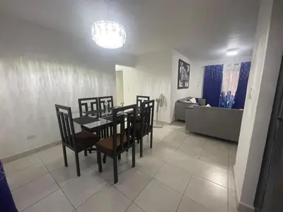 a dining room with a table and chairs and a living room at Apartamento en Caleta, La Romana in La Romana
