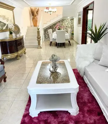 a living room with a white couch and a table at Casa con piscina Romana del Oeste in La Romana