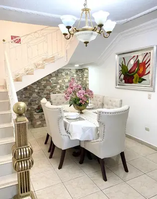 a dining room with a table and chairs and a staircase at Casa con piscina Romana del Oeste in La Romana