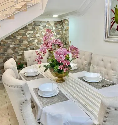 a dining room table with a vase of flowers on it at Casa con piscina Romana del Oeste in La Romana