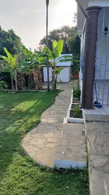 a stone walkway next to a house next to a yard at Kassuky Home in Cabarete