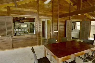 a dining room with a wooden table and chairs at Villa Jimi Las Terrenas in El Naranjito