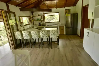 a kitchen with a island with bar stools at Villa Jimi Las Terrenas in El Naranjito