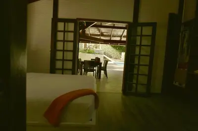 a bedroom with a bed and a dining room with a table at Villa Jimi Las Terrenas in El Naranjito