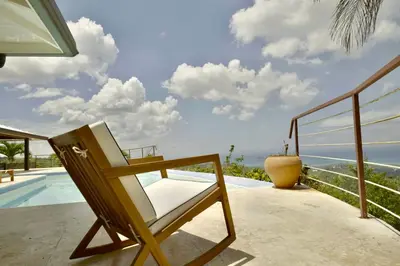 a chair sitting on a patio next to a swimming pool at Villa Lukner Las Terrenas in Las Terrenas
