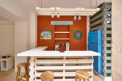 a kitchen with a table and two chairs and a refrigerator at Colonial House in Santo Domingo
