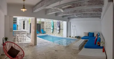 a living room with a swimming pool and a dining room at Colonial House in Santo Domingo