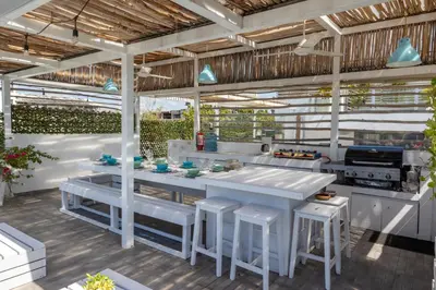 an outdoor kitchen with white tables and stools at Colonial House in Santo Domingo