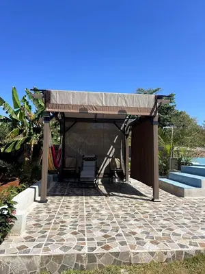 a pavilion with a table and chairs on a patio at Apartamento Dani's Guest House con piscina in Las Galeras