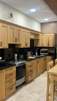 a kitchen with wooden cabinets and a stove top oven at Villa con piscina Infinitive in Concepción de La Vega