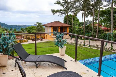 a balcony with a chair and a swimming pool at Villa Paz in San Felipe de Puerto Plata