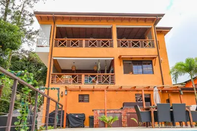 a building with a balcony with chairs in front of it at Villa Paz in San Felipe de Puerto Plata