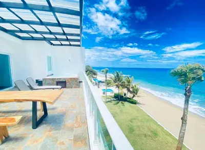 a view of the beach from the balcony of a house at Beachfront Luxury Penthouse in Sosúa