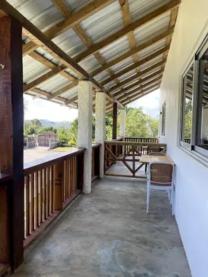 a porch with a wooden ceiling and a table at Habitacion 3 en Dani's Guest House in Las Galeras