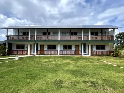 a large white building with a large yard at Habitacion 4 en Dani's Guest House in Las Galeras
