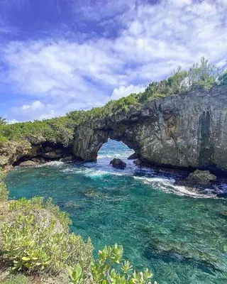 an archway in a cliff over a body of water at Habitacion 4 en Dani's Guest House in Las Galeras