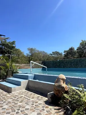 a swimming pool with some stairs and a rock at Habitacion con Jacuzzy en Dani's Guest House in Las Galeras