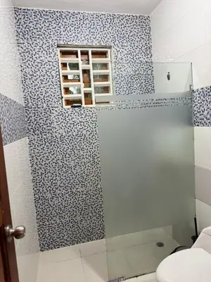 a bathroom with a shower with blue and white tiles at Hotel El Bonao in Higuey