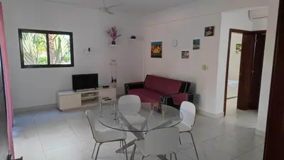 a living room with a glass table and chairs at Blue apt H1 - two queen bedroom - POOL- in Sosúa