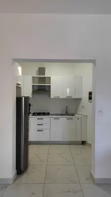 a kitchen with white cabinets and a black refrigerator at Blue apt H1 - two queen bedroom - POOL- in Sosúa