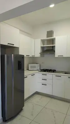 a kitchen with white cabinets and a stainless steel refrigerator at Blue apt H1 - two queen bedroom - POOL- in Sosúa