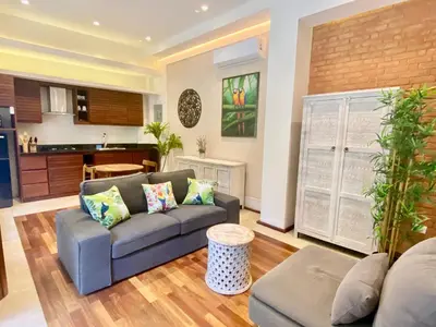 a living room with a couch and a kitchen at Boutique Hotel Casa Grande, Parrot's Paradise Suite in Santo Domingo