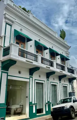 a building with a car parked in front of it at Boutique Hotel Casa Grande, Parrot's Paradise Suite in Santo Domingo