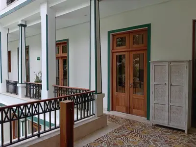 a white building with wooden doors and a balcony at Boutique Hotel Casa Grande, Mandala Suite in Santo Domingo