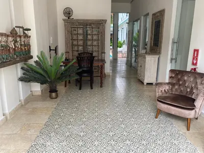 a hallway with a table and chairs and a table and a chair at Boutique Hotel Casa Grande, Mandala Suite in Santo Domingo