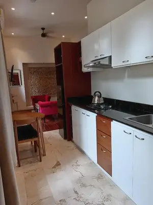 a kitchen with white cabinets and a wooden table at Boutique Hotel Casa Grande, Mandala Suite in Santo Domingo