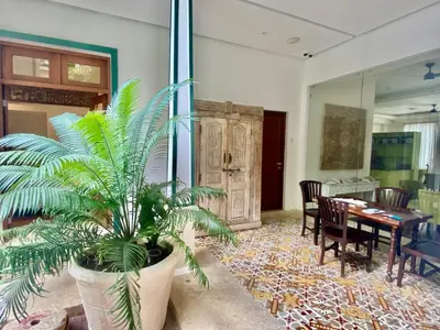a dining room with a table and a palm plant at Boutique Hotel Casa Grande, Chocolate Paradise, Estudio superior con Cocina in Santo Domingo